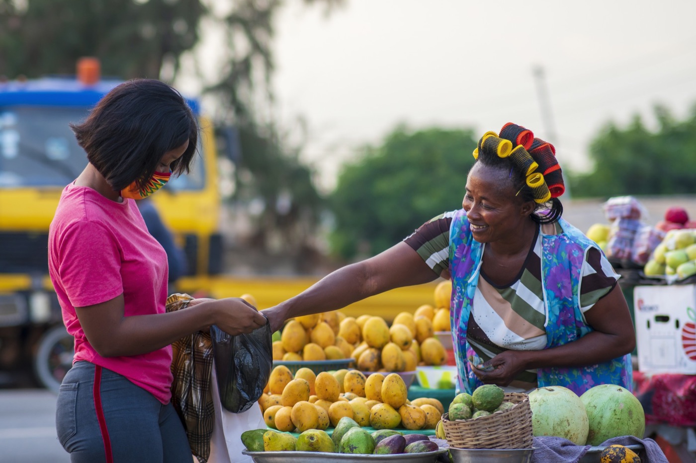 A market trader arranging fruit at her stall