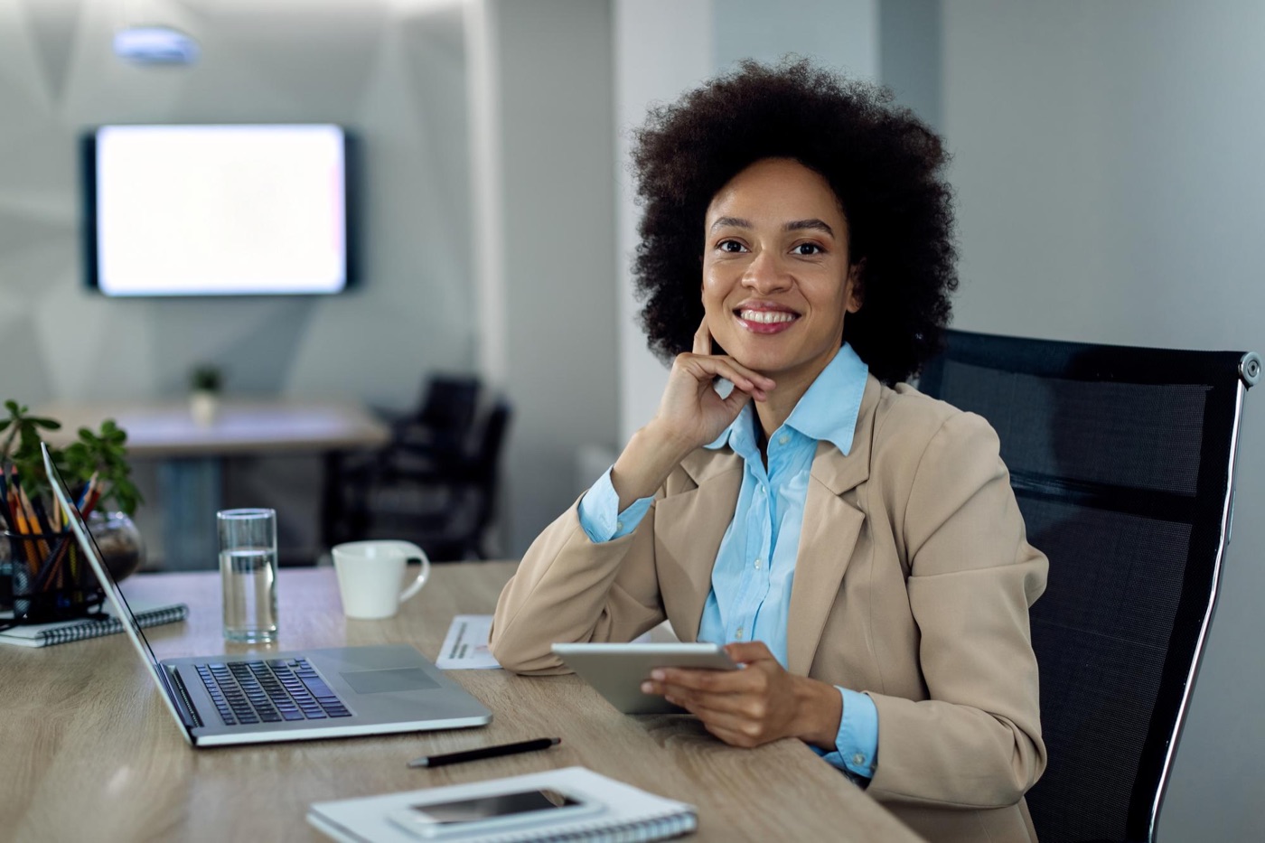 A salaried professional working at her desk with a tablet