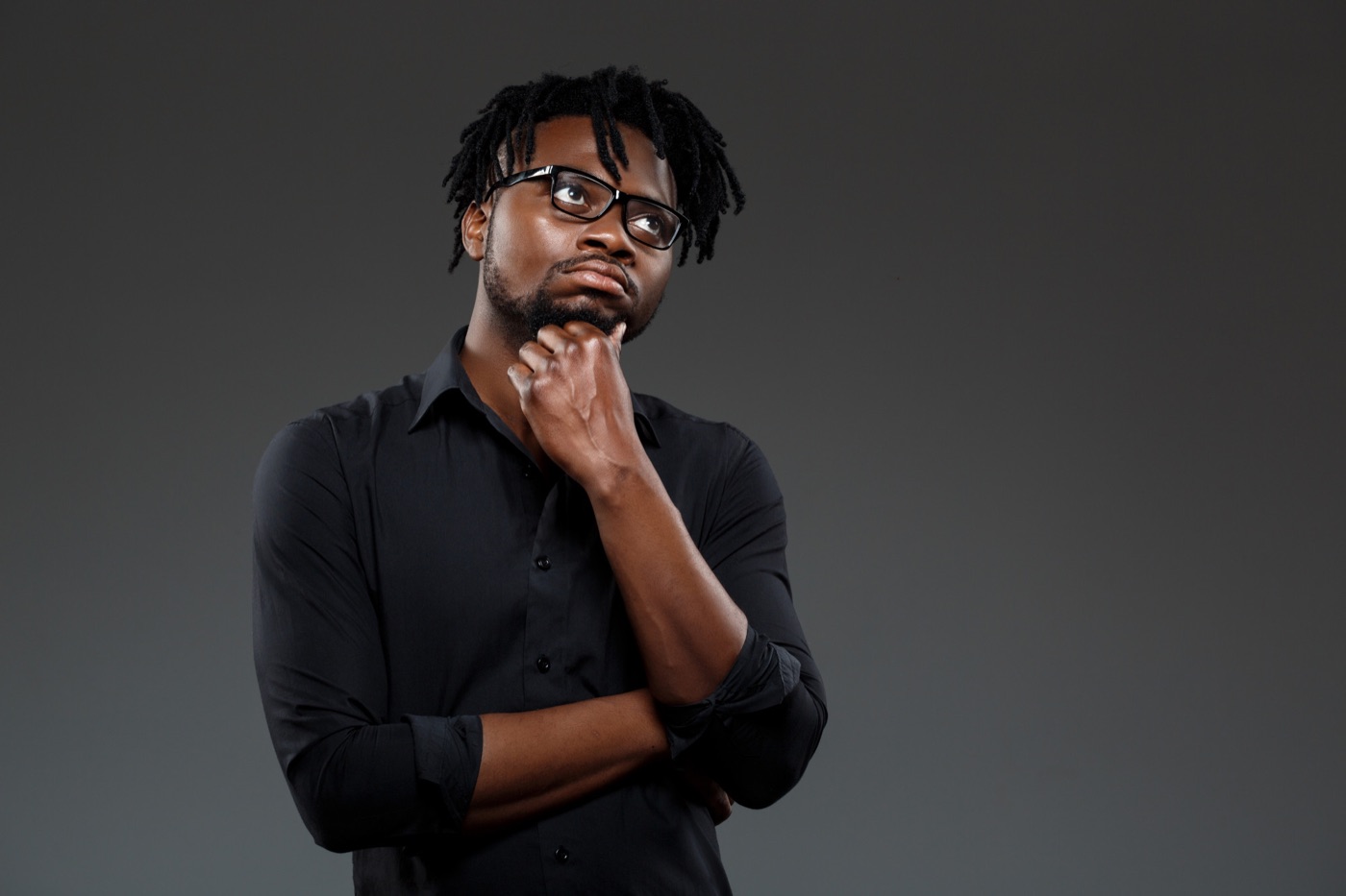 A man looking thoughtful with his hand on his chin